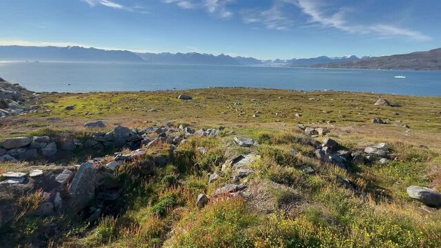 Panoramic panning view view at historical remains of Thule-culture winter houses on Denmark Island, Scoresbysund, Greenland.