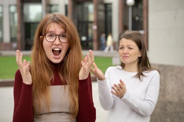 Young couple of lesbian women are arguing, quarreling outdoors. Problems in LGBT relationships.