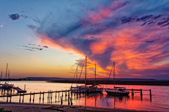Boats moored on Berg River with brilliant sunset