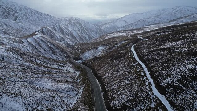 Wanaka, New Zealand: Aerial drone footage of the crown range mountain pass road between Wanaka and Queenstown in the southern alps in winter in New Zealand