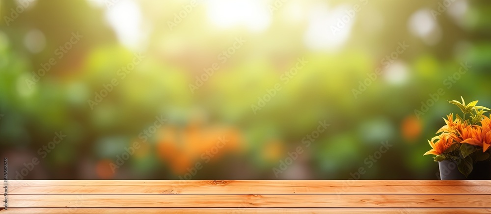 Poster wooden table with blurred orange garden background suitable for product display or visual design wit