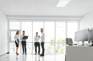 Fototapeta premium Team at work. Group of young business people in smart casual wear working together in creative office
