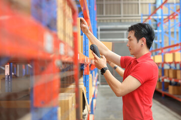 Warehouse workers asian man scanning barcode on large box package for delivery to production stock and inventory in retail warehouse logistics, distribution center