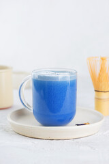 Vegan blue matcha latte drink made from clitoria flowers with coconut milk in a cup. Healthy drink, lactose, gluten and sugar free.