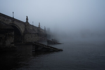 Dreamy morning view of the Charles Bridge with magical foggy atmosphere on early morning with Vltava river in the Old Town of amazing historic city Prague, Czech Republic, Europe.