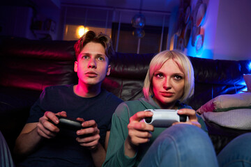 Caucasian couple playing video game with game pads