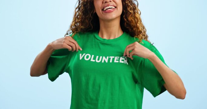 Woman, support and pointing in studio as a volunteer with pride at charity event or ngo on blue background. Mockup, portrait and hand gesture for volunteering, sign up and confidence with happiness