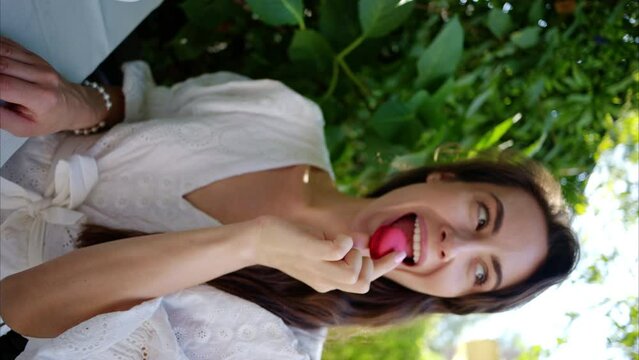 Woman eating red macaroon, composition with flowers, macaroons sweets desert and coffee and tea