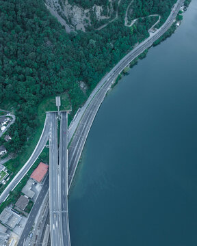 Aerial view of a road and a railway following the Lugano Lake coastline in Melide, Ticino, Switzerland.
