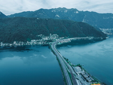 Aerial view of a road crossing the Lugano lake at sunset, Melide, Ticino, Switzerland.
