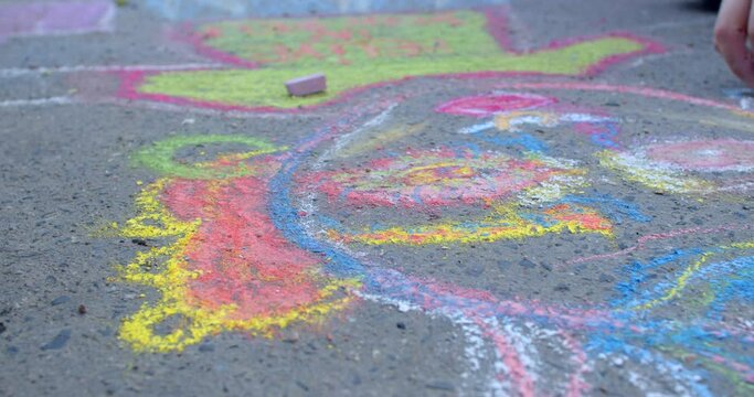 Drawing made with colorful chalk on the asphalt. Creativity and self-expression as way for artist or artists to convey their thoughts, feelings, and inspiration. Respecting and appreciating street art