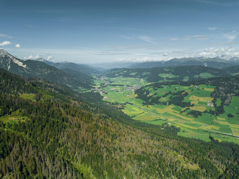 Aerial view of Dobbiaco town as seen from Croda dei Baranci (Birkenkofel) mountain peak on the Dolomites range, Trentino, South Tyrol, Italy.