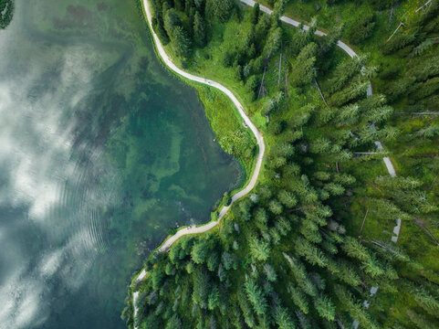 Aerial view of Misurina Lake coastline with forest along the coast at sunset, Auronzo di Cadore, Dolomites, Veneto, Italy.