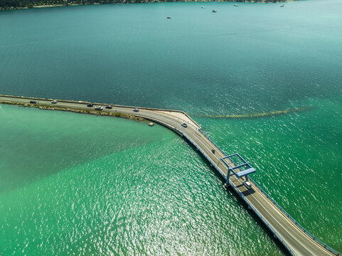 Aerial view of vehicles driving a road crossing the Mirna lagoon and Mirna river, Antenal, Istria, Croatia.