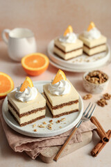 Orange and walnut cake, decorated with whipped cream and fresh orange slices, on a white plate. Orange background.