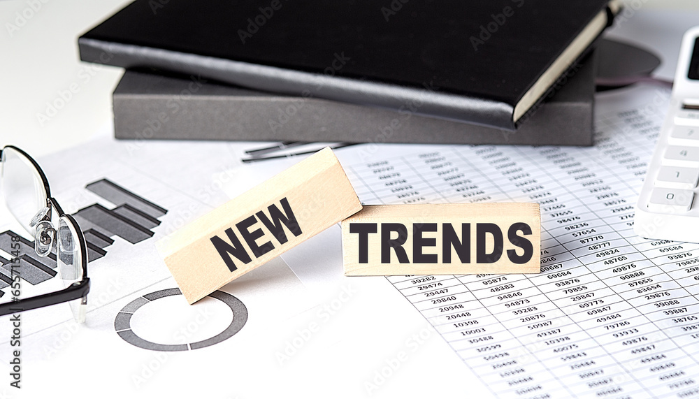 Poster new trends - text on a wooden block with chart and notebook