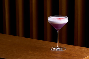 Classic cocktail glass on wooden table in night club restaurant.
