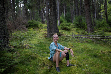 Naklejka na ściany i meble woman relaxing in pine forest with dog