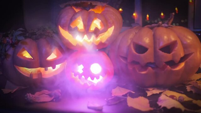 Lots of carved holiday jack-o'-lanterns glow with colorful lights in the smoke. Beautiful Halloween background