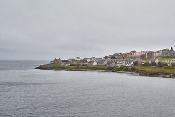Lerwick island town center coastline surrounded by North Sea and grey sky.