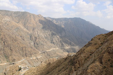 A beautiful view of the mountain road of Al Bahah, Saudi Arabia during the day. This road goes up high between high mountains.