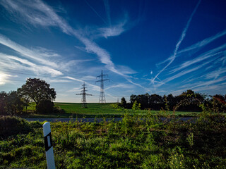 Strommasten un Wolkenhimmel am Abend