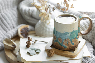 Cozy composition with a cup of tea, books and a knitted element.