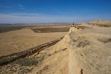 Hiker at Mirador de Juan Obispo looking at desert landscape of the arid plateau of the Bardenas...