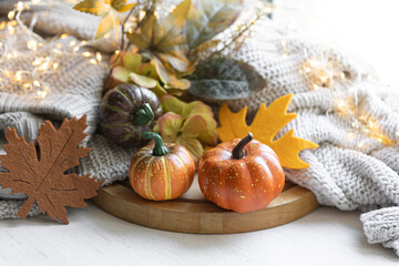 Autumn still life with pumpkins, leaves and knitted element.