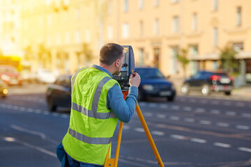Survey engineer work with theodolite, measure vertical and horizontal angles. Unrecognizable man with electronic, optical instrument, total station theodolite used for surveying.