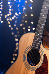 Close-up, acoustic guitar on a dark background with bokeh lights. © puhimec