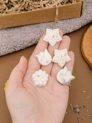 Woman holds handmade aroma sachets in the form of flowers