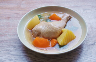 boiled chicken leg with potato and carrot couple onion soup on plate