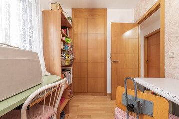 Bedroom with shelves, built-in wardrobe, wooden floors and study table on the other side