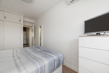 double bedroom with matching duvet and cushions, combination of white furniture and built-in wardrobe with sliding doors
