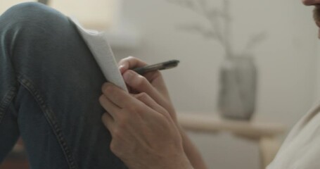 Talented male songwriter writing song lyrics on bed