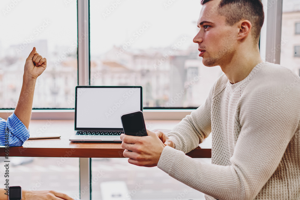 Poster colleagues communicating with each other between computer with blank screen area