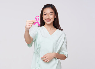 Happy smile asian woman patient showing pink badge ribbon chest to support breast cancer cause...