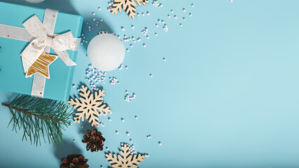 Christmas composition with gift boxes, decorations, snowflakes on a light blue background. Top...