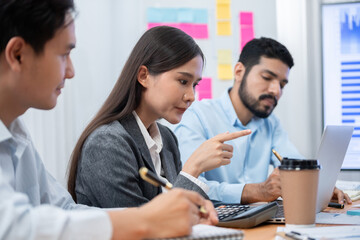 Multiracial analyst team use BI dashboard data to analyze financial report on meeting table. Group of diverse business people utilize data analysis by FIntech for success business marketing. Concord