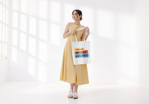 Mockup of woman holding customizable tote bag, full length