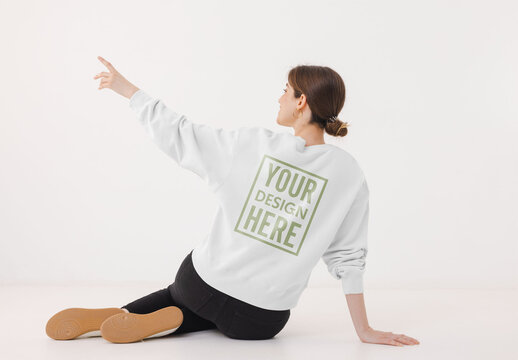 Mockup of woman wearing customizable color sweatshirt pointing, rear view