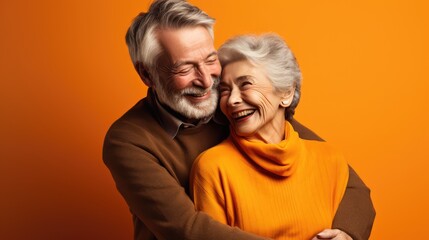Un couple de personnes âgées, seniors heureux, arrière-plan coloré orange. - obrazy, fototapety, plakaty