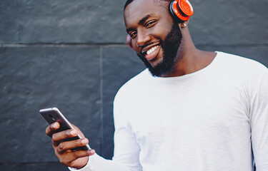  positive hipster guy listening player during leisure time outdoors