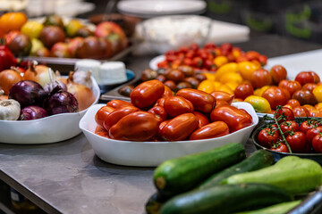 different types of tomatoes, red, yellow, green, lie on the table in the kitchen