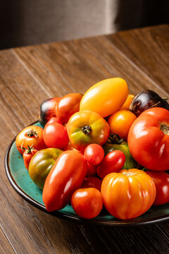 different types of tomatoes, red, yellow, green, lie in a plate on the table