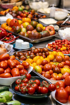 different types of tomatoes, red, yellow, green, lie on the table in the kitchen