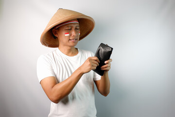 Indonesian farmer showing shocked expression when looking to his empty wallet