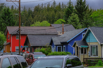 Street city view with wooden houses, shops, cars and mountain wilderness nature in Ketchikan,...