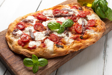 Pinsa romana condita con pomodoro, mozzarella e acciughe, cibo italiano 